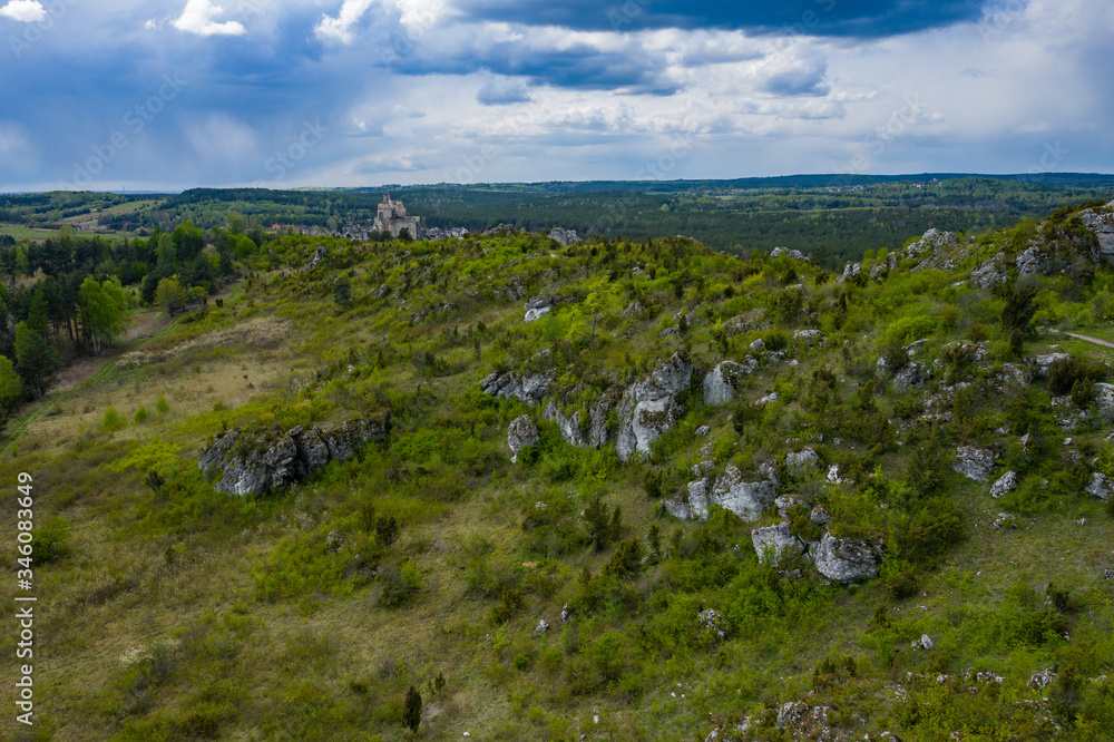 Aerial view of limestone rock formations in green located near Krakow in Poland. Shots from the drone showing the vast green hilly areas of the Cracow-Częstochowa highlands. Kraków-Częstochowa Jura.