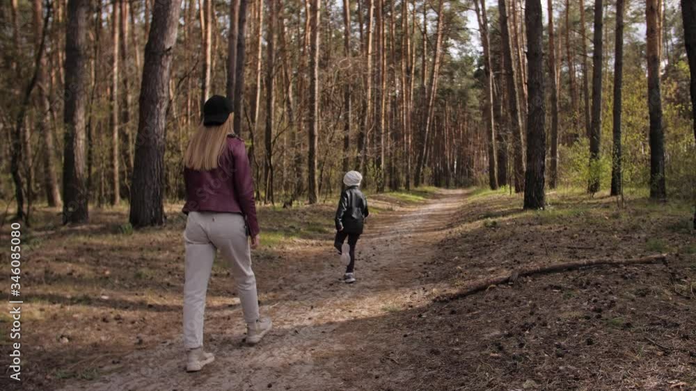 Mother and daughter walk together in the forest. Mother and daughter walk together in the forest.