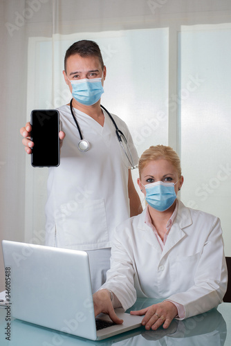 Couple of doctors with devices show empty smartphone screen