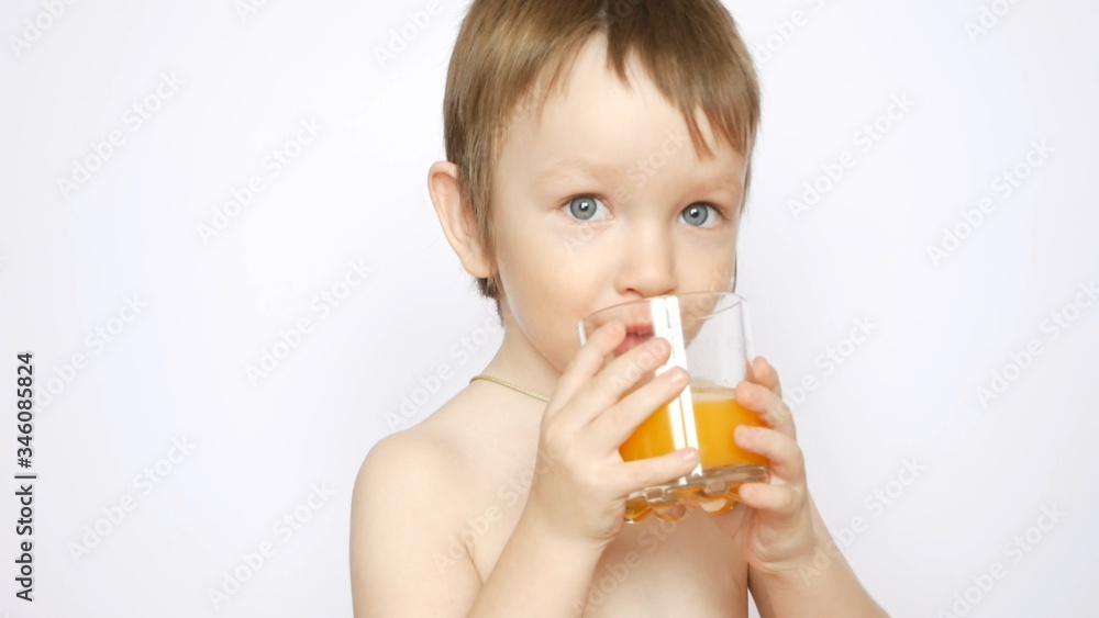 A beautiful naked boy drinks fresh orange juice from a glass A beautiful naked boy drinks fresh orange juice from a glass