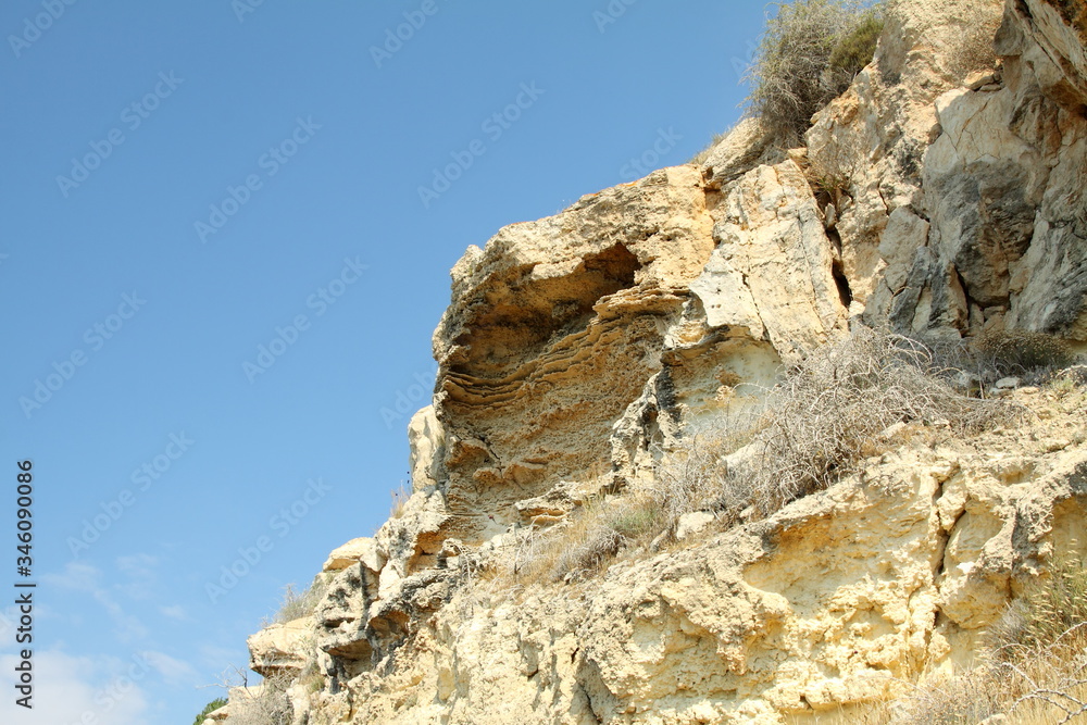 Photo of a mountain cliff against a blue sky.