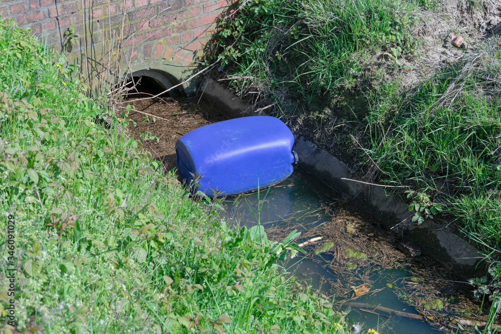 Blue plastic barrel dumped in nature Blue plastic barrel dumped in nature