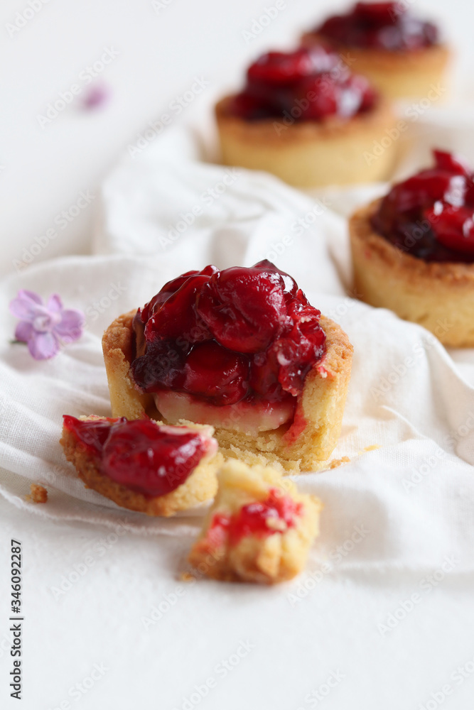 Tarts with fresh cherry and custard, delicious dessert on a white background, close-up.