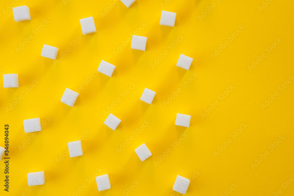 Refined sugar cubes shot on a yellow background. Background for sweets, food and drinks.