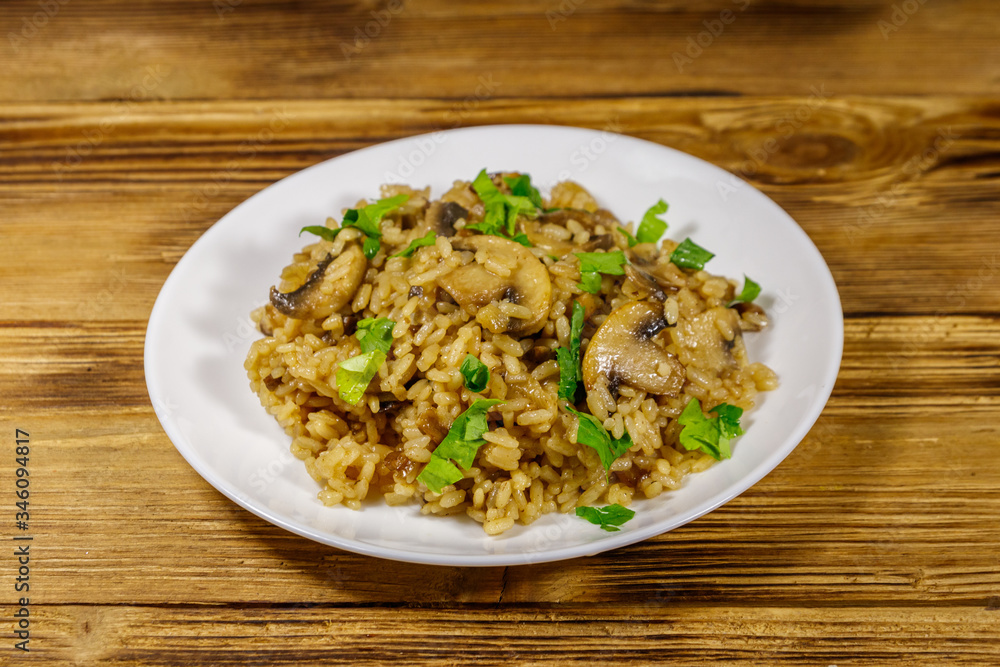 Tasty risotto with mushrooms on wooden table Tasty risotto with mushrooms on wooden table