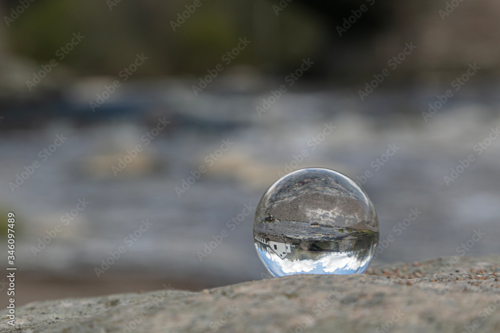 Glass ball on a background of a waterfall Glass ball on a background of a waterfall