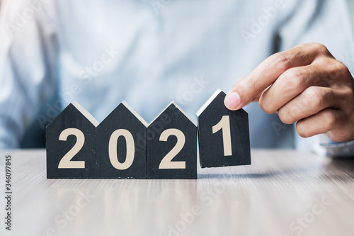 Wallpaper Mural Young Businessman hands holding 2021 Happy New Year with house model on table office. New House, Financial, Property insurance, real estate, savings and New Year Resolution concepts Torontodigital.ca
