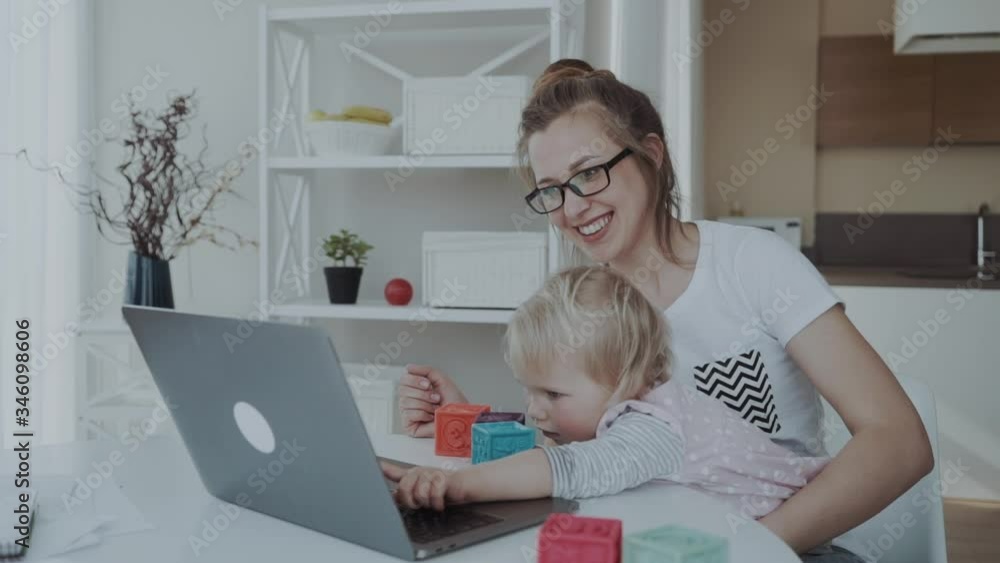Mother woman with a toddler working at the computer, played with a laptop Mother woman with a toddler working at the computer, played with a laptop