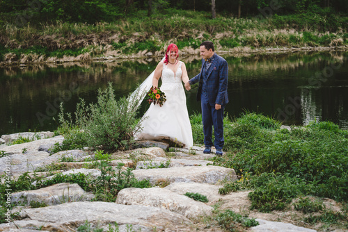 Brautpaar am Fluss mit Schleier und Anzug