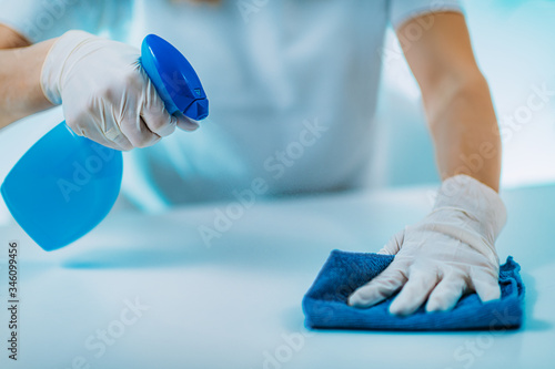 Tableau sur toile Surface Disinfection. Woman Disinfecting Table Surface