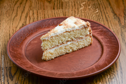 Delicious white cake, vanilla cake topping decorated with whipped cream. Served on a ceramic plate.