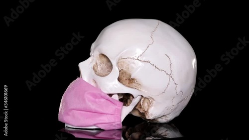 A human skull In Medical Mask  on a dark background. Concept Of Deadly Coronavirus Epidemic. covid-19.