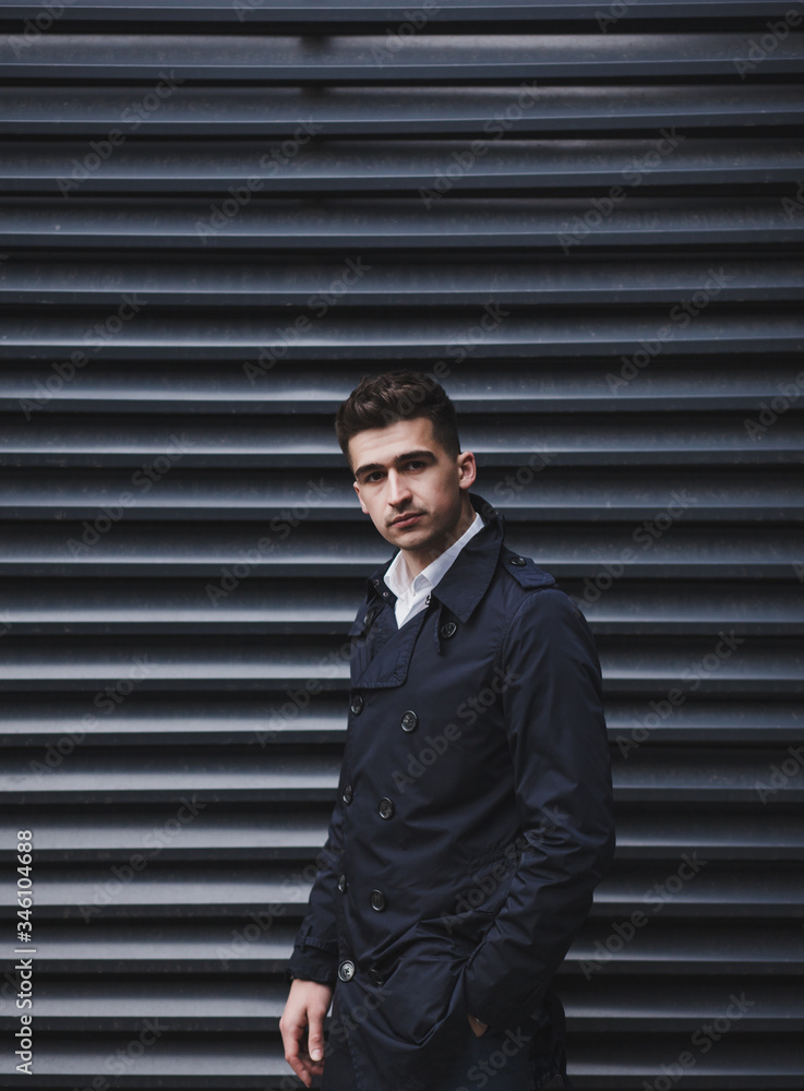 Stylish man in elegant coat posing near wall Stylish man in elegant coat posing near wall
