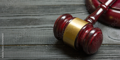 Law concept - Open law book with a wooden judges gavel on table in a courtroom or law enforcement office isolated on white background. Copy space for text