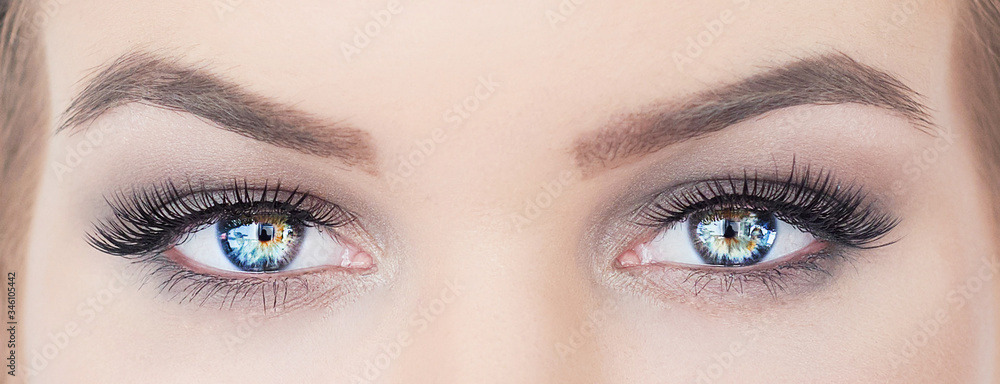 Fototapeta premium woman with beautiful blue eyes with long eyelashes. hypnotic look closeup. smoky eyes make up