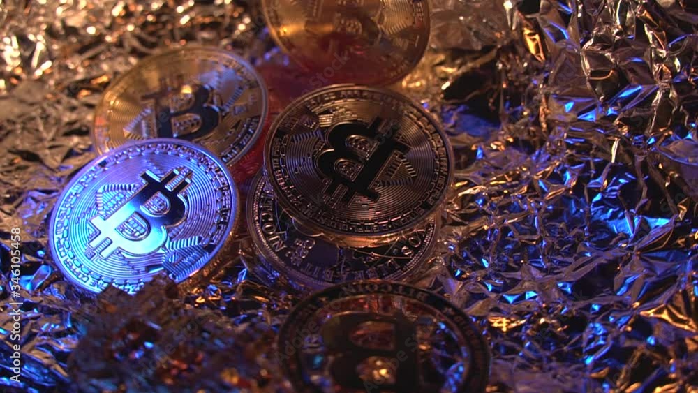 Five cripto coins Bitcoin BTC rotate on the table with gold and blue neon light and nice background. Currency of the future. Crypto halving,