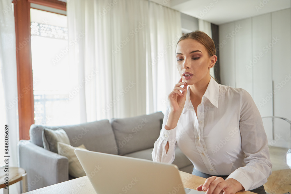 Concentrated young beautiful businesswoman working on laptop in home office. islolation, virus concept Concentrated young beautiful businesswoman working on laptop in home office. islolation, virus concept