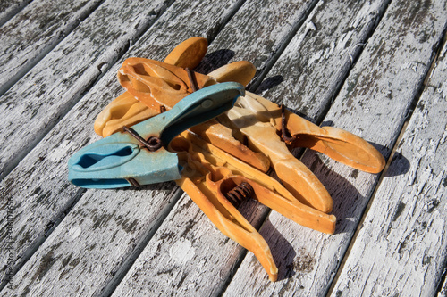 Old used dirty rusted plastic and metal clothes pegs or pin on a wooden table