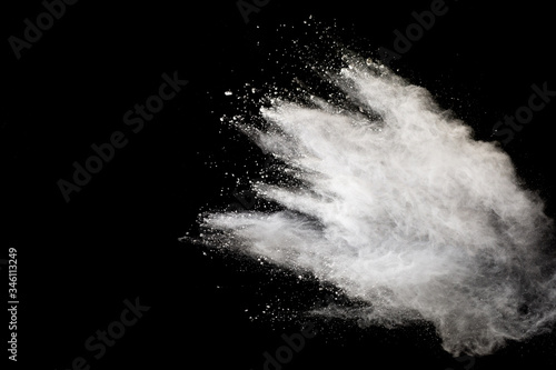 White powder explosion isolated on black background.White dust particles splash.
