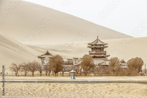 DUNHUANG,CHINA-MARCH 11 2016: Temple at Mingsha shan Gobi desert, sand mountain and Crescent moon lake in Dunhuang, silk road at Gansu, northwest of China photo