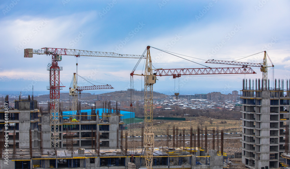 cranes and building with blue sky