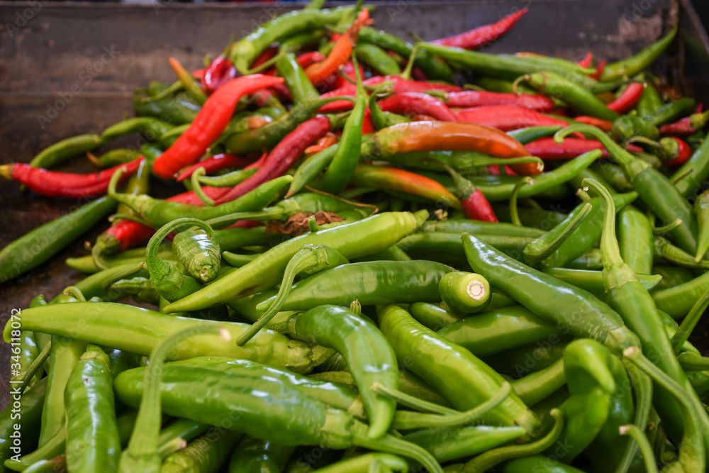 Green and red chili on a counter top of a store during food festival market. Green and red chili on a counter top of a store during food festival market.