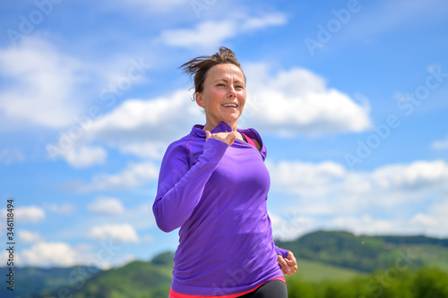 Fototapeta Naklejka Na Ścianę i Meble -  Fit active woman jogging running in spring sun