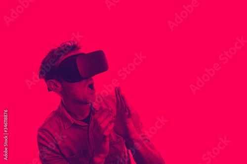 Man in his 30's wearing a VR virtual reality headset. Graphic duotone style photo