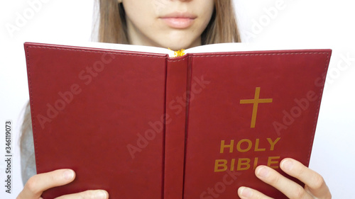 A young beautiful woman reads the Holy Bible