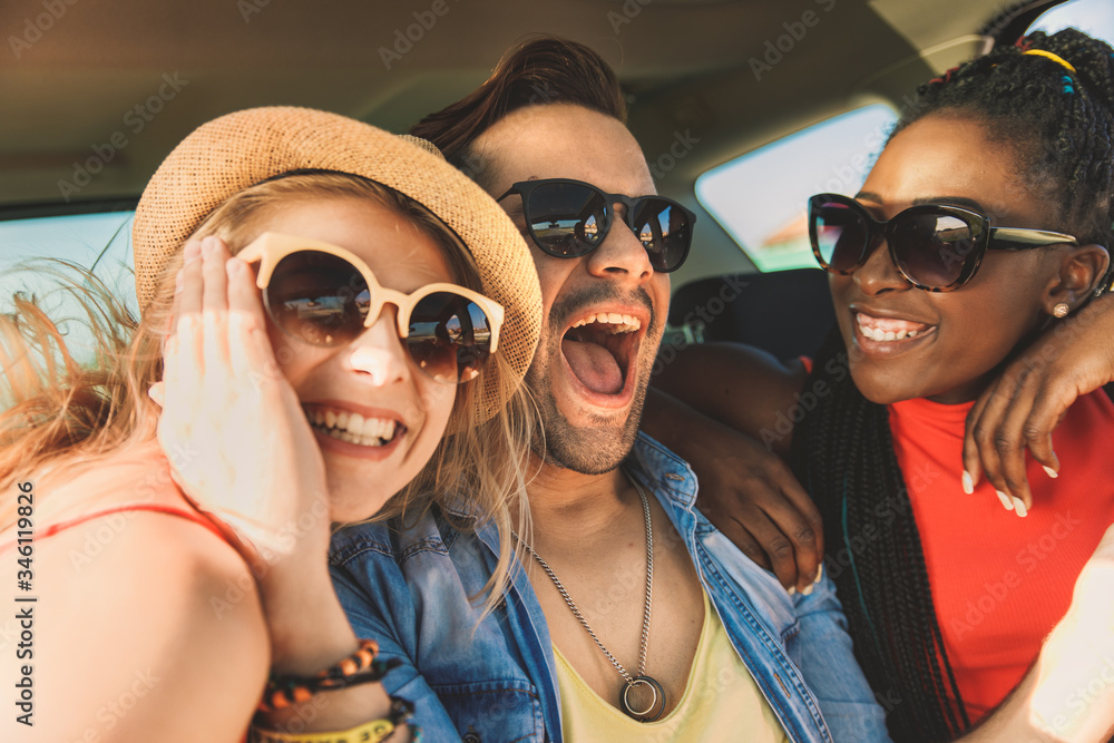 Three best friends enjoying traveling in the car, sitting in rear seat and having lots of fun on a road trip. Three best friends enjoying traveling in the car, sitting in rear seat and having lots of fun on a road trip.