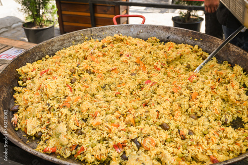 Seafood paella cooked in a large pan wok, street food festival. Mexican fiesta national day