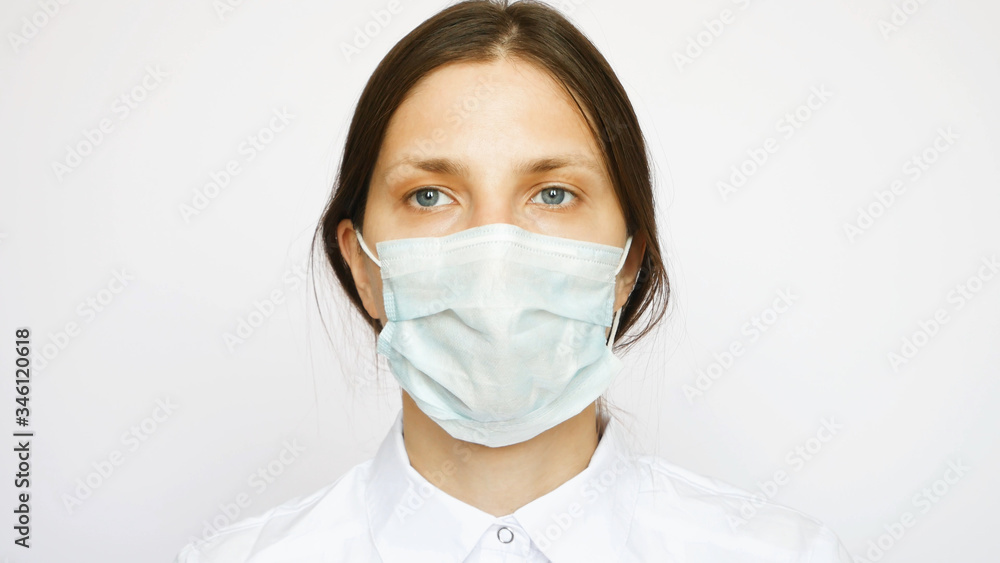 A portrait of pretty nurse with a protective mask looks into the distance A portrait of pretty nurse with a protective mask looks into the distance