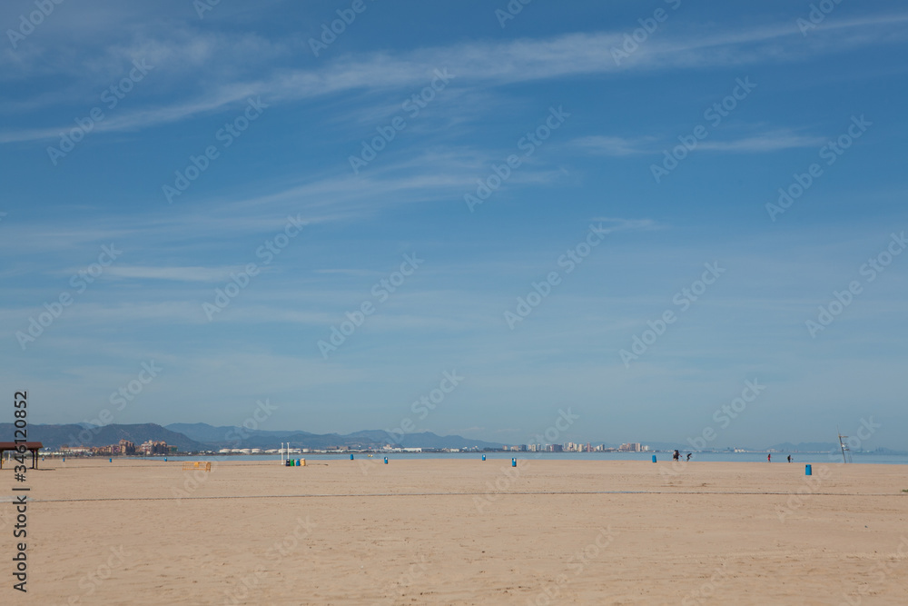 Deserted beaches during siesta and quarantine without people. Blue sky and bright sun and white sand. Valencia, Spain