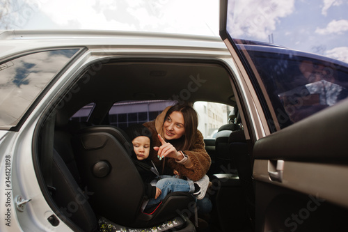 Young mother and child in car. Baby seat on chair. Safety driving concept. © AS Photo Family