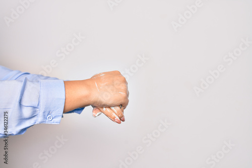 Young caucasian woman cleaning hands using alcohol liquid over isolated white background