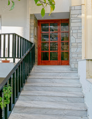 contemporary house entrance with marble stairs to wood and glass door  Athens Greece