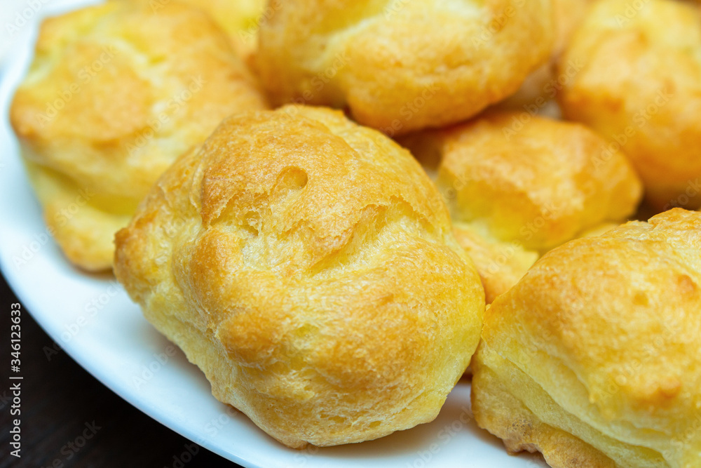 homemade profiteroles on a white plate close up