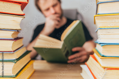 A man with a book between stacks of books - passionate about the novel - classic literature