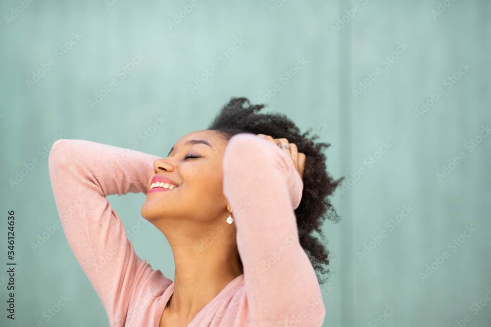 Close up carefree young african american woman with hands in hair