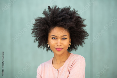Fotografie front portrait attractive young black woman with afro hairstyle by green backgro