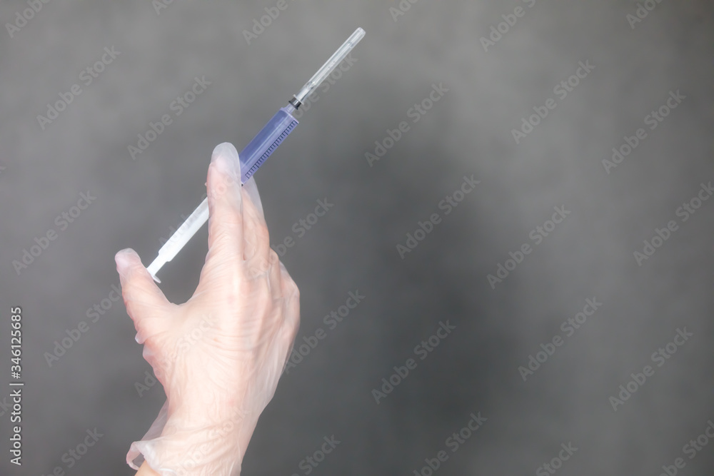 The nurse holds a syringe in her hand and prepares to give the patient an injection The nurse holds a syringe in her hand and prepares to give the patient an injection