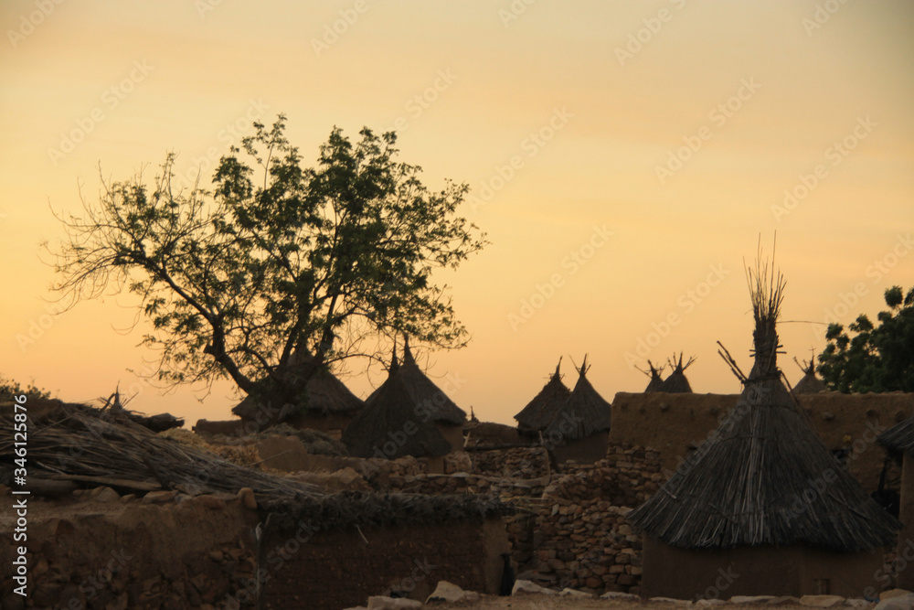 tradycyjne chaty afrykańskie starego plemienia na tle wieczornego nieba - obrazy, fototapety, plakaty 