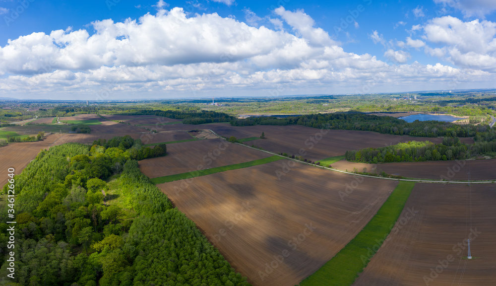 aerial view of fields and forests in spring with beautiful clouds