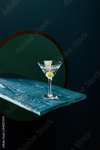 Принти на полотні cocktail glass with vermouth and whole olive on toothpick on blue wooden surface