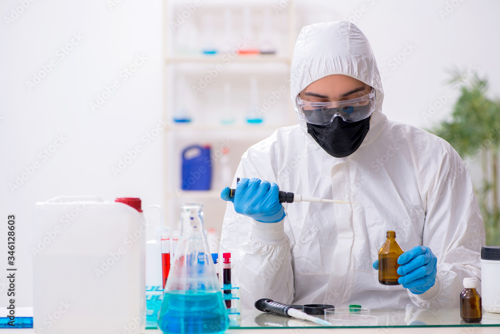 Young male chemist working in medicine lab Young male chemist working in medicine lab