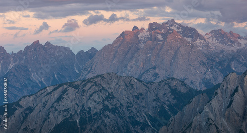 Mountain landscape in the European Dolomite Alps underneath the Three Peaks with alpenglow during sunset  coloured clouds in the sky  South Tyrol Italy.