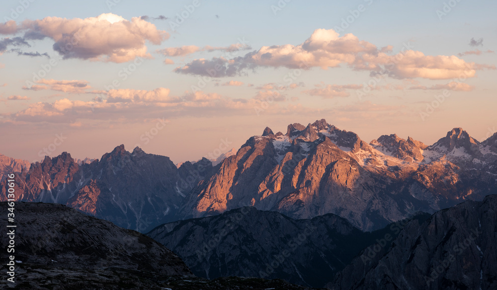 Mountain landscape in the European Dolomite Alps at the Three Peaks with alpenglow during sunset, layers of mountains, South Tyrol Italy.
