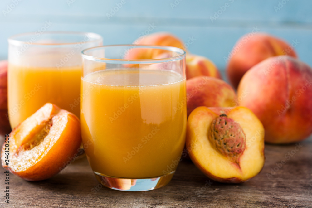 Natural peach juice in glass on wooden table Natural peach juice in glass on wooden table