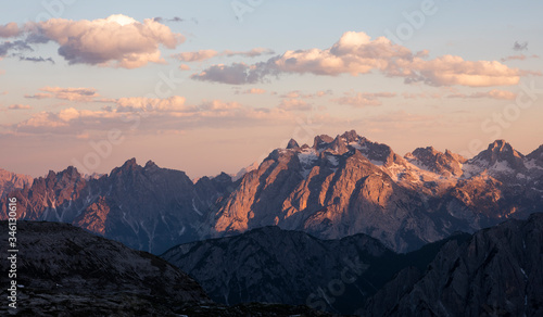 Mountain landscape in the European Dolomite Alps at the Three Peaks with alpenglow during sunset, layers of mountains, South Tyrol Italy. © Bastian Linder