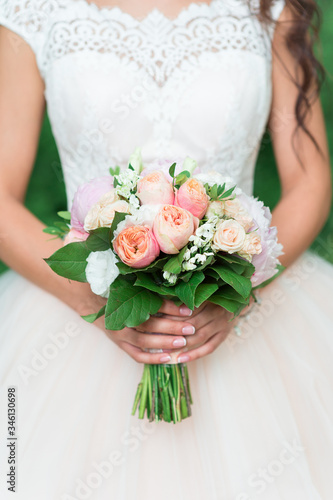 Beautiful wedding bouquet in the hands of the bride close-up